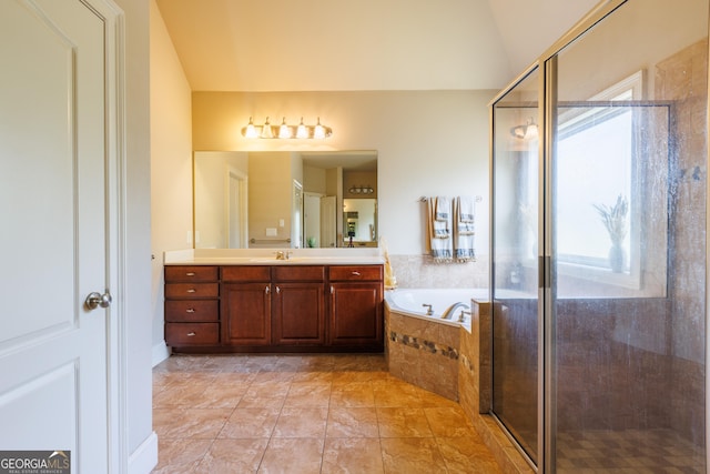 bathroom featuring vanity, lofted ceiling, a garden tub, and a shower stall