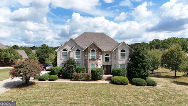view of front of property with brick siding, a front lawn, and french doors