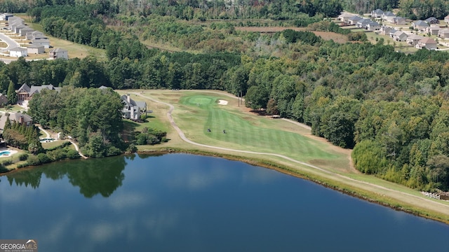 drone / aerial view featuring a water view, view of golf course, a residential view, and a forest view