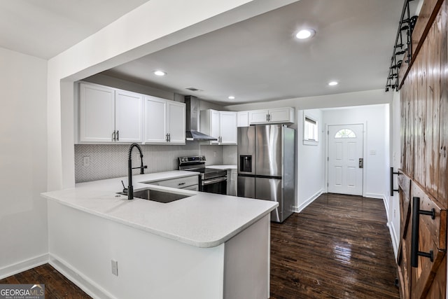 2195 Penelope St NW, Atlanta, GA 30314 - kitchen featuring stainless steel appliances, wall chimney exhaust hood, light countertops, backsplash, and recessed lighting