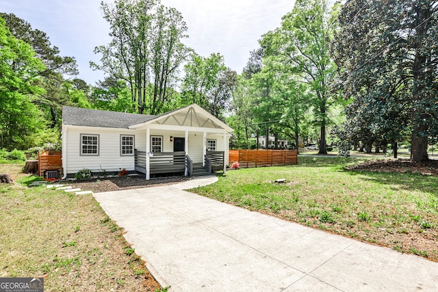 2195 Penelope St NW, Atlanta, GA 30314 - bungalow-style home with a porch, a front yard, and view of wooded area