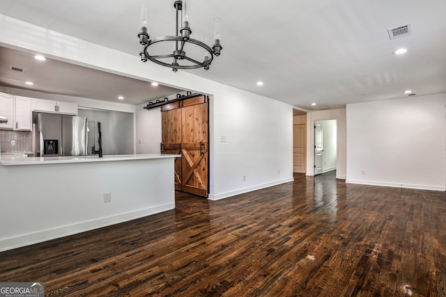 2195 Penelope St NW, Atlanta, GA 30314 - unfurnished living room with a barn door, dark wood-type flooring, recessed lighting, and a chandelier