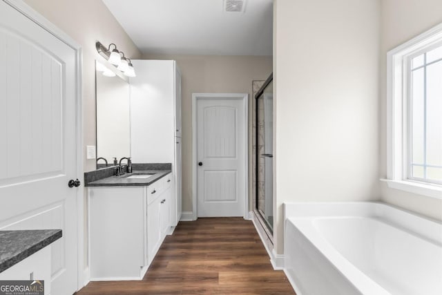 1515 Cabin Creek Trl, Griffin, GA 30223 - full bathroom with a bath, visible vents, a shower stall, wood finished floors, and vanity