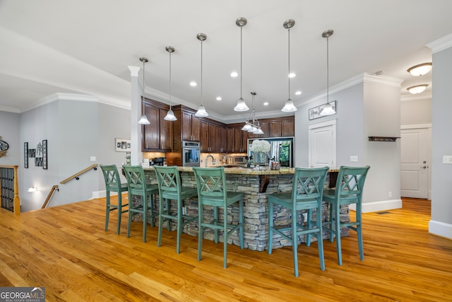 160 Evans Dr, Bogart, GA 30622 - kitchen with stainless steel oven, fridge, light wood-type flooring, dark brown cabinetry, and crown molding