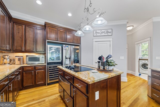 160 Evans Dr, Bogart, GA 30622 - kitchen featuring washer / dryer, stainless steel microwave, a warming drawer, black electric stovetop, and a center island