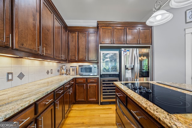 160 Evans Dr, Bogart, GA 30622 - kitchen featuring black electric stovetop, stainless steel microwave, tasteful backsplash, light wood finished floors, and light stone countertops