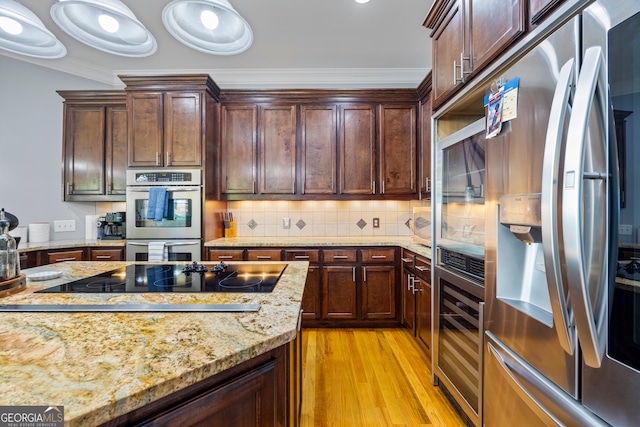 160 Evans Dr, Bogart, GA 30622 - kitchen with appliances with stainless steel finishes, light wood finished floors, beverage cooler, crown molding, and light stone counters