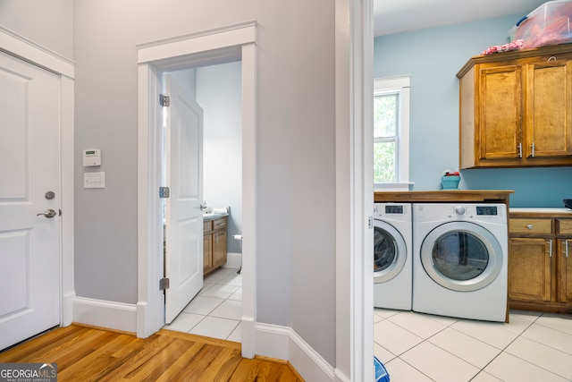 160 Evans Dr, Bogart, GA 30622 - laundry area with washing machine and dryer, cabinet space, baseboards, and light tile patterned floors