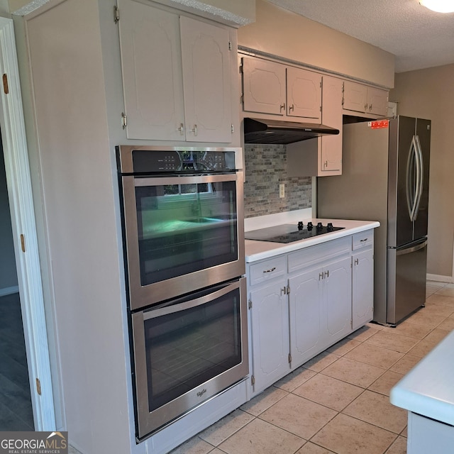 6000 Caribou Dr, Columbus, GA 31907 - kitchen featuring stainless steel appliances, under cabinet range hood, tasteful backsplash, light countertops, and a textured ceiling