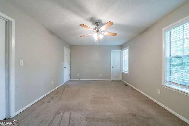 744 Brittany Ct, Stone Mountain, GA 30083 - carpeted spare room with a ceiling fan, baseboards, a healthy amount of sunlight, and a textured ceiling