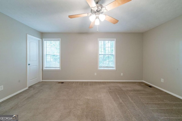 744 Brittany Ct, Stone Mountain, GA 30083 - carpeted spare room featuring plenty of natural light, visible vents, baseboards, and ceiling fan
