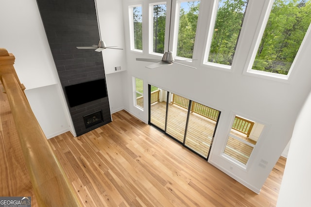 4039 Tallow Pl, Woodstock, GA 30188 - unfurnished living room with a towering ceiling, healthy amount of natural light, light wood-type flooring, and a fireplace