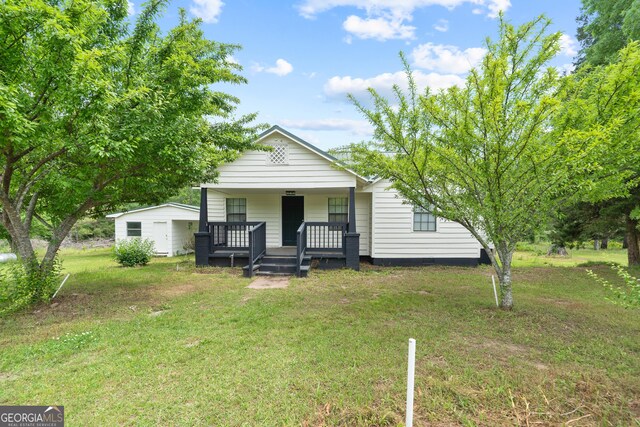 bungalow-style house featuring covered porch and a front yard