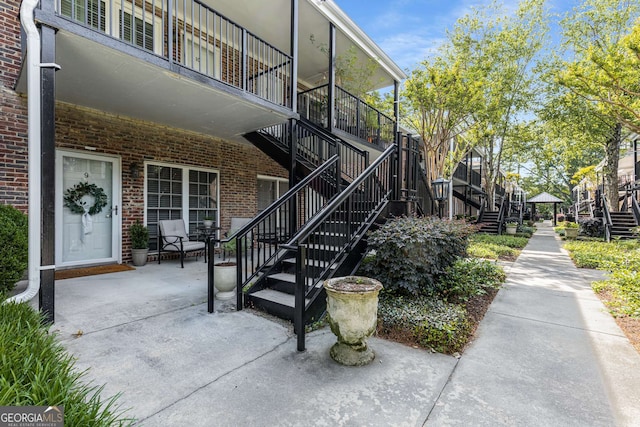 doorway to property featuring brick siding and a patio area