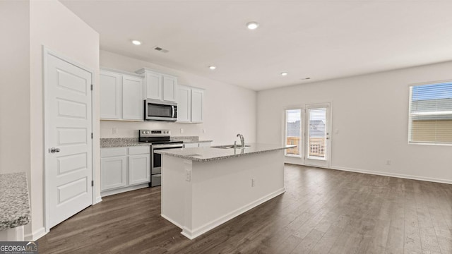 kitchen featuring appliances with stainless steel finishes, dark wood finished floors, white cabinetry, and visible vents