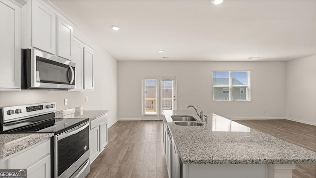 kitchen featuring a sink, appliances with stainless steel finishes, wood finished floors, and white cabinetry