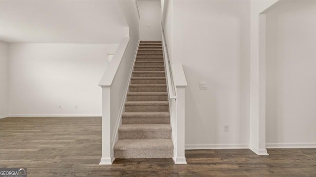 staircase with baseboards and wood finished floors