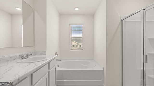 bathroom featuring a shower stall, a bath, and vanity