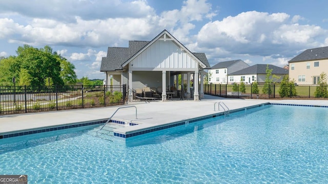 pool featuring fence, a patio area, and a residential view