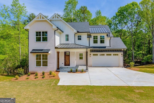 modern farmhouse style home featuring a front lawn, driveway, and a standing seam roof