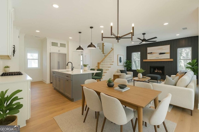 kitchen featuring light countertops, light wood-style flooring, baseboards, custom range hood, and tasteful backsplash