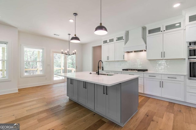 kitchen featuring ceiling fan, a sink, light countertops, stainless steel appliances, and white cabinetry