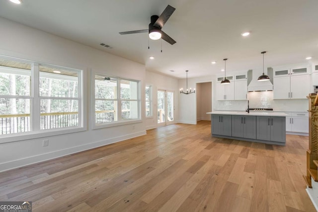 kitchen with white cabinets, baseboards, light wood-style flooring, and light countertops
