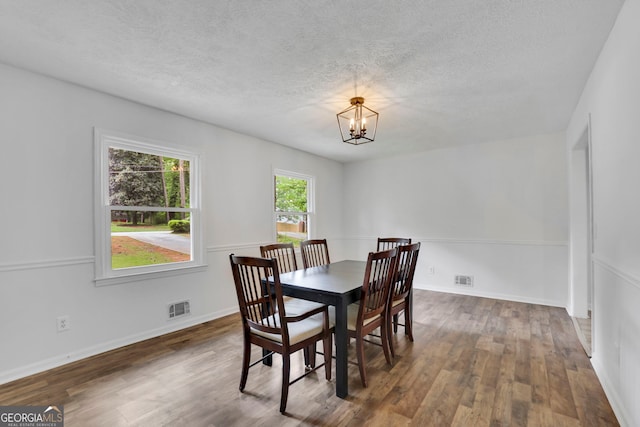 4420 Lake Breeze Dr, Stone Mountain, GA 30083 - dining space featuring a textured ceiling, visible vents, wood finished floors, and an inviting chandelier