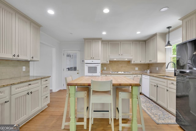 4420 Lake Breeze Dr, Stone Mountain, GA 30083 - kitchen with white appliances, butcher block countertops, a sink, light wood-style flooring, and backsplash