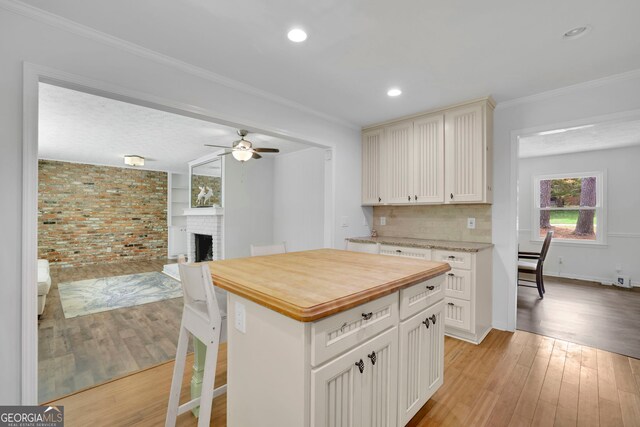 4420 Lake Breeze Dr, Stone Mountain, GA 30083 - kitchen with a fireplace, wooden counters, a ceiling fan, open floor plan, and light wood-type flooring