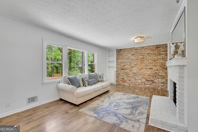 4420 Lake Breeze Dr, Stone Mountain, GA 30083 - living room featuring visible vents, a textured ceiling, wood finished floors, and a fireplace