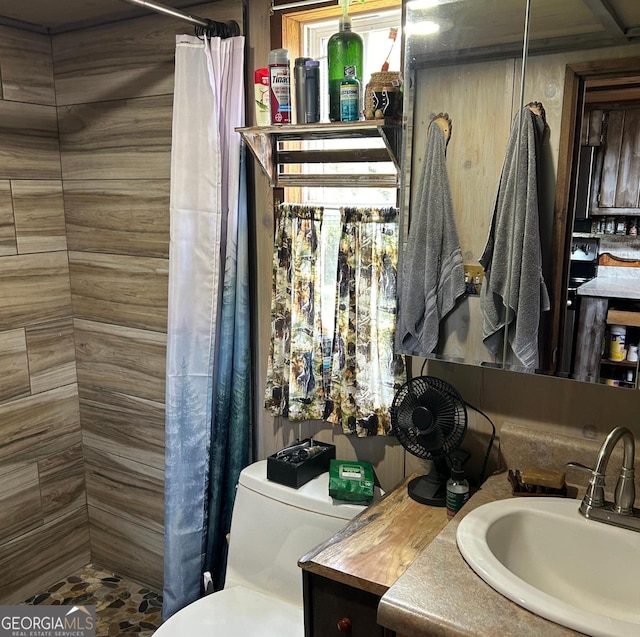 full bathroom with vanity, a tile shower, and toilet