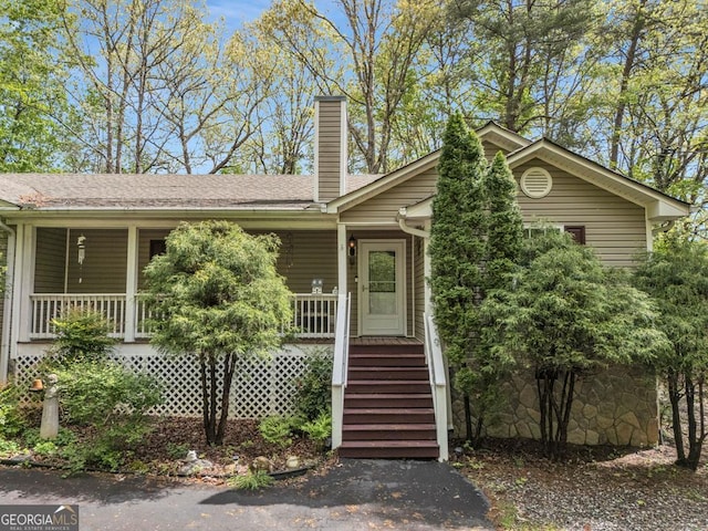 view of front of property with a porch and a chimney