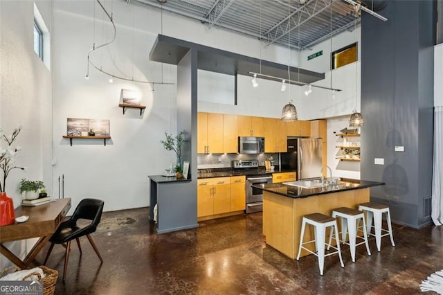 195 Arizona Ave Unit 104, Atlanta, GA 30307 - kitchen with a high ceiling, appliances with stainless steel finishes, dark countertops, and finished concrete floors