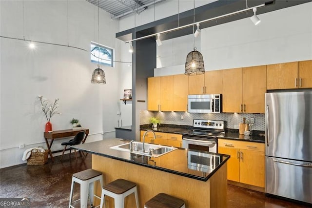 195 Arizona Ave Unit 104, Atlanta, GA 30307 - kitchen with a towering ceiling, a kitchen bar, tasteful backsplash, a sink, and appliances with stainless steel finishes
