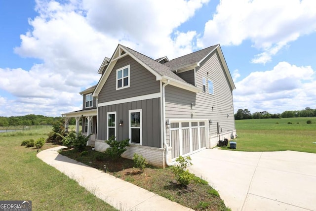 125 Leveret Rd, Locust Grove, GA 30248 - view of side of home featuring a lawn, driveway, a garage, and board and batten siding
