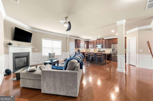 3755 Lake Haven Way, Atlanta, GA 30349 - living room with ornamental molding, a decorative wall, ornate columns, a wainscoted wall, and dark wood finished floors
