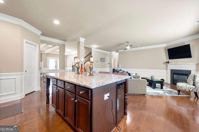 3755 Lake Haven Way, Atlanta, GA 30349 - kitchen featuring ornamental molding, wainscoting, ceiling fan, a glass covered fireplace, and wood finished floors