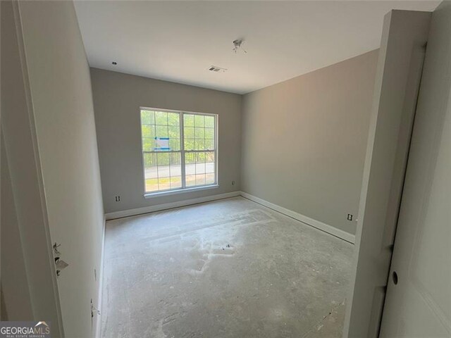 unfurnished room featuring baseboards, visible vents, and concrete floors