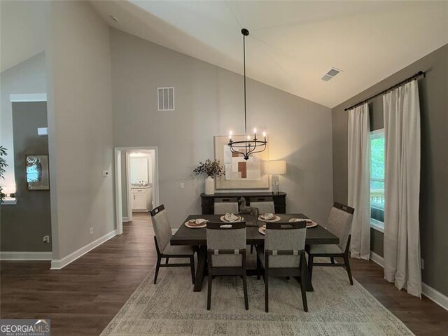 dining space with visible vents, baseboards, wood finished floors, and a notable chandelier