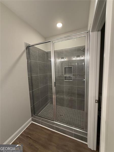 full bathroom featuring baseboards, a shower stall, recessed lighting, and wood finished floors