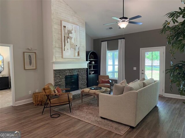 living area featuring baseboards, visible vents, dark wood-style floors, and a fireplace