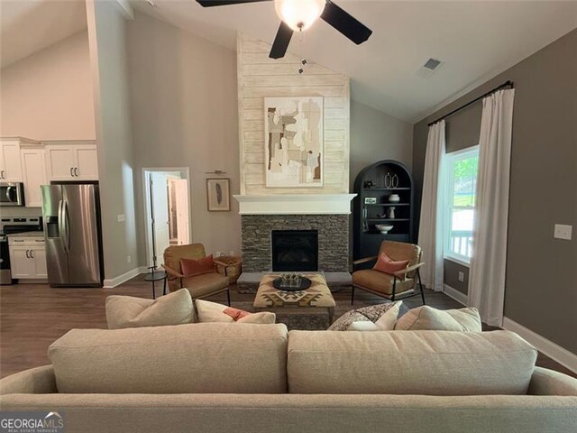 living room with ceiling fan, a stone fireplace, visible vents, high vaulted ceiling, and baseboards