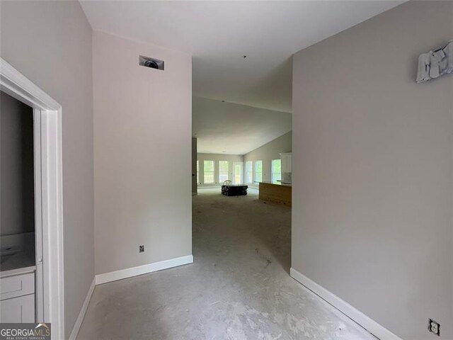 interior space featuring baseboards and lofted ceiling