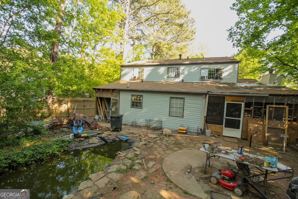 back of house with a patio, a chimney, fence, and a sunroom