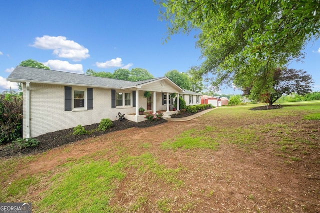 3415 Trickum Rd, Woodstock, GA 30188 - ranch-style home featuring covered porch, brick siding, a front lawn, and a shingled roof