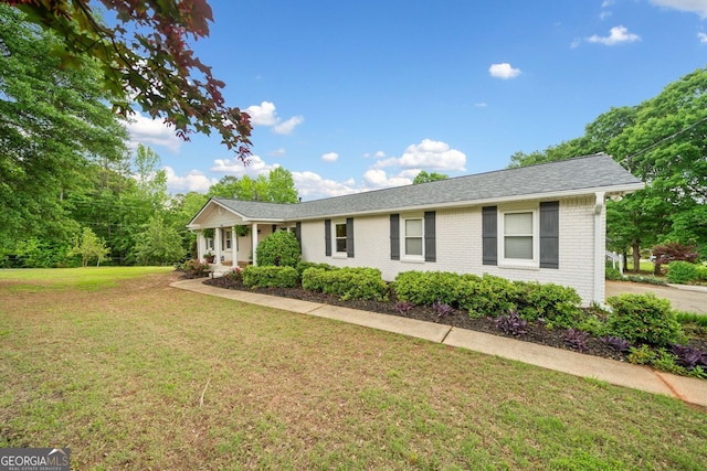 3415 Trickum Rd, Woodstock, GA 30188 - ranch-style house featuring a front yard, brick siding, roof with shingles, and covered porch