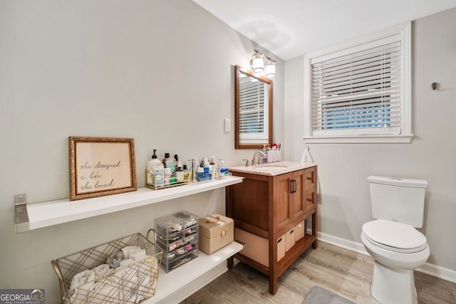 3415 Trickum Rd, Woodstock, GA 30188 - bathroom with wood finished floors, toilet, baseboards, and vanity