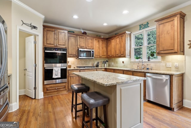 121 Ridge View Dr, Ball Ground, GA 30107 - kitchen featuring stainless steel appliances, brown cabinetry, light wood-style flooring, ornamental molding, and recessed lighting