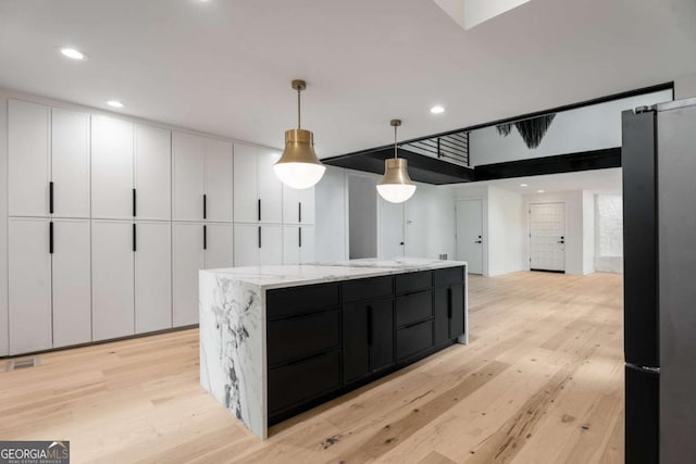 5020 Vallo Vista Ct, Atlanta, GA 30342 - kitchen featuring freestanding refrigerator, recessed lighting, dark cabinetry, light wood finished floors, and white cabinets